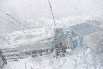 A heavy snowstorm while on a moving cable car looking at the window