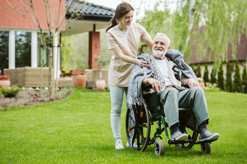 Fototapeta premium Senior man with helpful volunteer in the garden of professional care home