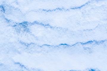 blue texture of an snow surface with pure white wave , blue cold clear cryslallized wall background ,winter frozen lake side close up , abstract macro wallpaper