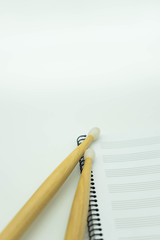 Vertical view Wooden sticks on music notebook with pentagram. Concept music.