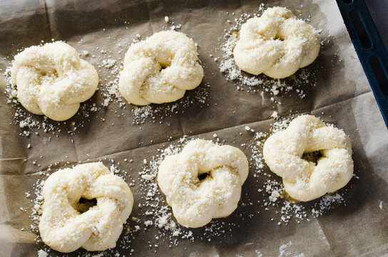 Preparation process - raw unbaked buns. Ready to bake homemade traditional buns on baking paper.