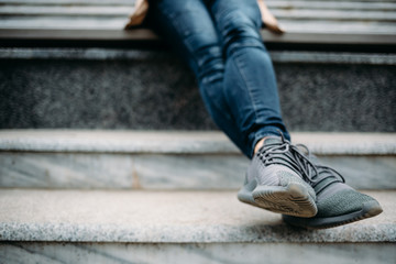 Close-up of female's legs wearing dark blue jeans