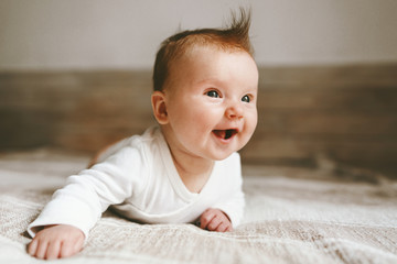 Smiling baby infant crawling at home adorable child portrait family lifestyle 3 month old kid - obrazy, fototapety, plakaty