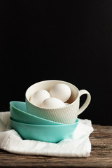 Traditional easter food eggs. Colored dishes on a wooden table and black background. Minimalistic design. White napkin. Colors Trend 2020
