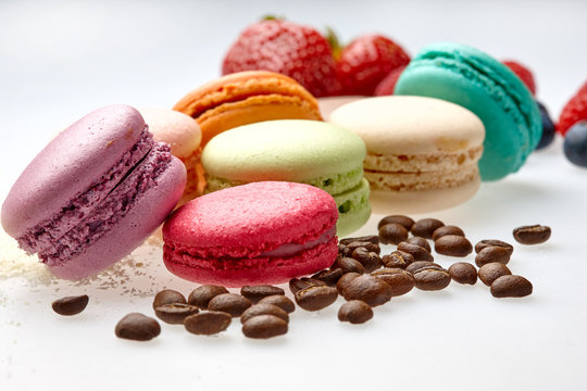 round baked almond flour macaron isolated on a white background, delicious popular french dessert coffee beans almond Strawberry malina raspberries blueberries flour