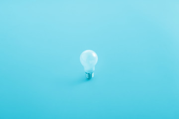 light bulb in aqua blue background, minimalism, idea, conceptual images, can easily change the colour tone, and text as a design.