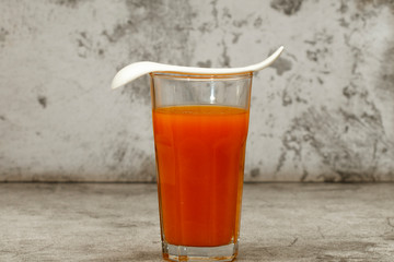 Fresh pumpkin carrot juice on a gray background. Copy space. Place for text.