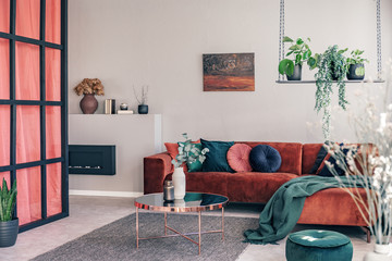 Pillows and blanket on modern sofa in bright living room interior