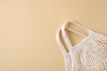 Mesh shopping bag at beige background. Zero waste concept.