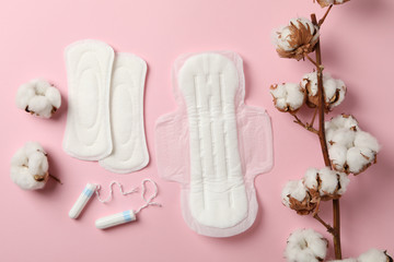 Sanitary pads, tampons and cotton on pink background