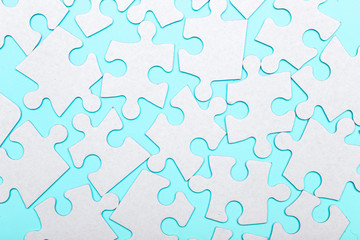 Pieces of a puzzle connected on a blue background with many other pieces of the puzzle. Business teamwork concept