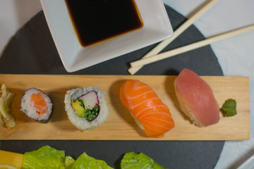 Aerial view of sushi with sauce, chopsticks, soybeans and wasabi on the table