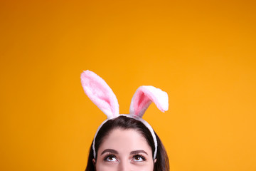 Studio portrait of young beautiful woman wearing traditional bunny ears headband for easter and...