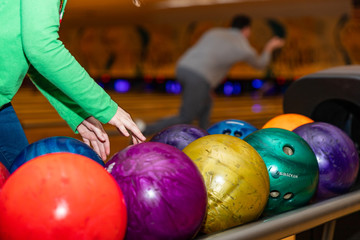 Fototapeta na wymiar Child's hands reaching to pick up bowling ball at Bowling alley