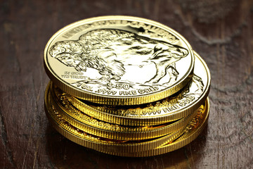 1 ounce American Buffalo gold bullion coins on wooden background