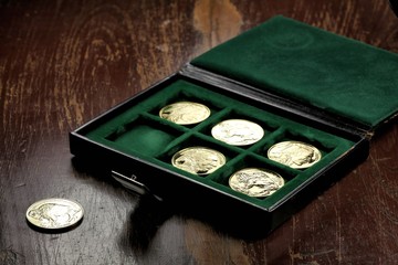 1 ounce American Buffalo gold bullion coins in a coin box on wooden background
