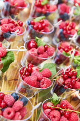 Cups with fresh berries in summer garden.