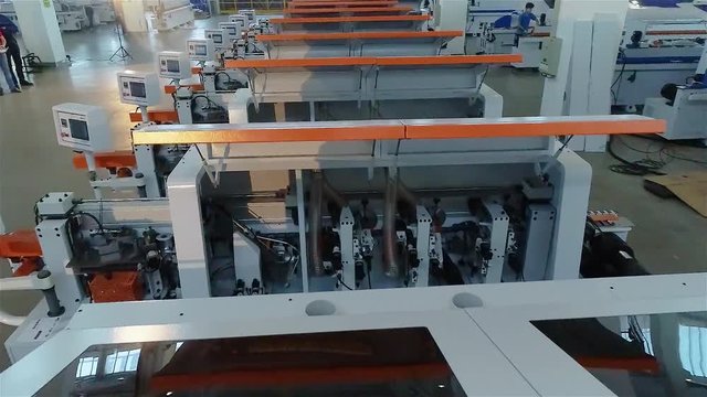 A large factory for the production of automated machine tools. Manufactured woodworking machines stand in a row in stock. Warehouse of woodworking machines