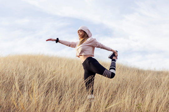 Young woman exercise in dry grass  after joggin in the nature