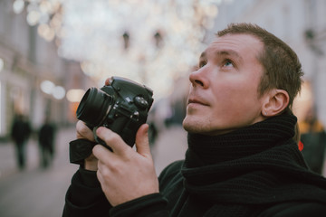 Fototapeta premium A man with a camera photographs the street of the old city in winter