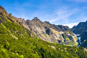 Fototapeta na wymiar Panoramic view of the Seven Granats ridge - Siedem Granatow - and Zabia Czuba peak within the Zabia Gran range over Rybi Potok Valley in Tatra Mountains, near Zakopane in Poland