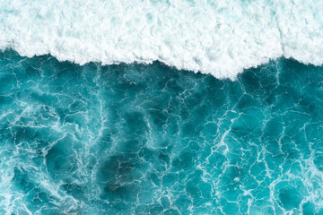 Fototapeta premium Texture Light blue surface of raging sea water with white foam and wave pattern