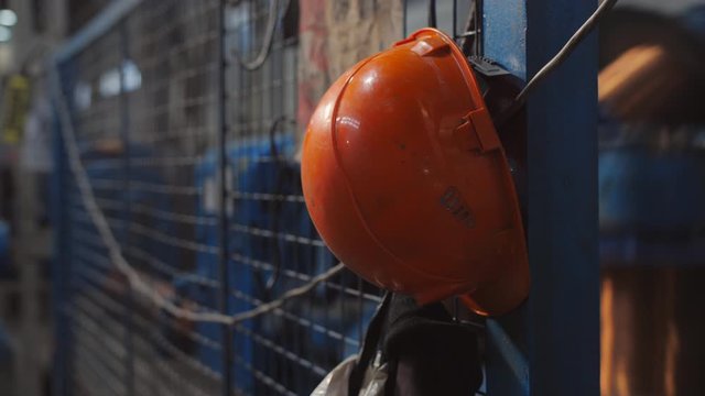 Close-up of the orange helmet of the worker on the factory.