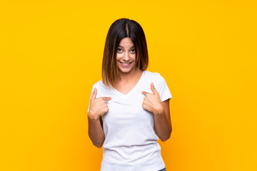 Young woman over isolated yellow background with surprise facial expression