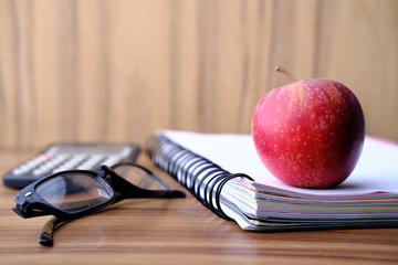 close up of apple on a notepad on table 