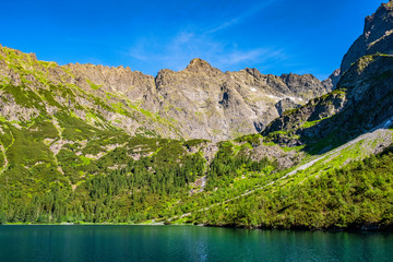 Fototapeta na wymiar Lower Rysy - Niznie Rysy - and Rysy peaks rising above Czarny Staw pod Rysami and Morskie Oko lakes in Tatra Mountains in Poland