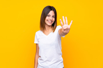 Young woman over isolated yellow background happy and counting four with fingers