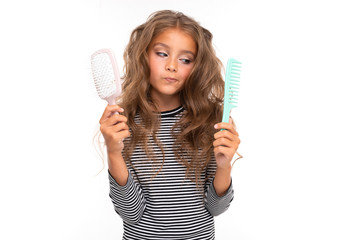 Young girl with beautiful brown hair chooses between two hair combs