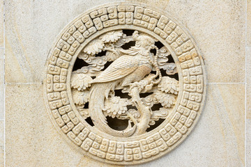 Stone pattern with a bird holding beads in its beak on the territory of Buddhist center Nanshan.
