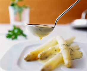 Gekochter spargel auf Teller mit Hollandaise sauce in der Kelle