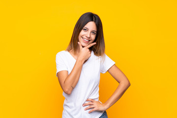 Young woman over isolated yellow background smiling