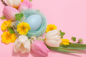 Easter eggs and spring flowers on pink background