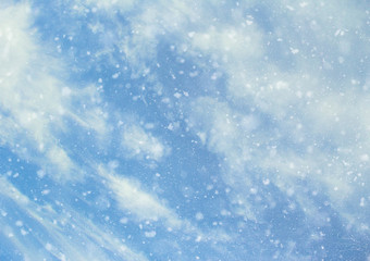 Blue sky background with clouds and snow. Winter blue lights view, de-focused