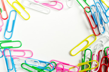 Colorful paper clips isolated on white with free space in the centre.