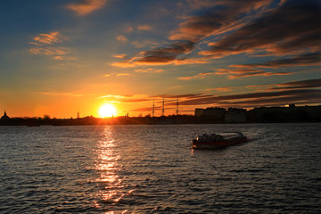 Fototapeta na wymiar pleasure boat floating on the river in the rays of the setting sun