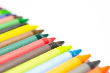 Colourful bright wax pencils isolated on white, close-up selective focus.