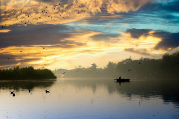 Early morning at yamuna ghat with golden sun, fog and blue water