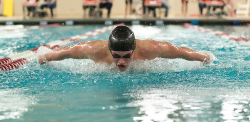 Young male swimmer swims the butterfly during a competition