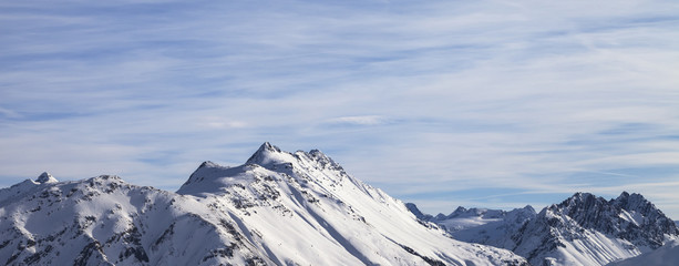 Snowy high winter mountains and beautiful cloudy sunlit sky