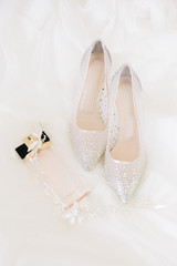 Fototapeta na wymiar Bridal accessories. Bridal shoes, perfume and crown.