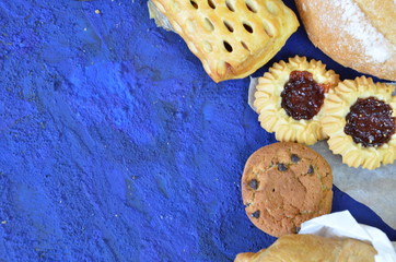 Different kinds of bread rolls on black board from above. Kitchen or bakery poster design. muffin,...