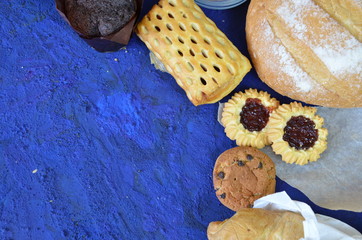 Different kinds of bread rolls on black board from above. Kitchen or bakery poster design. muffin,...