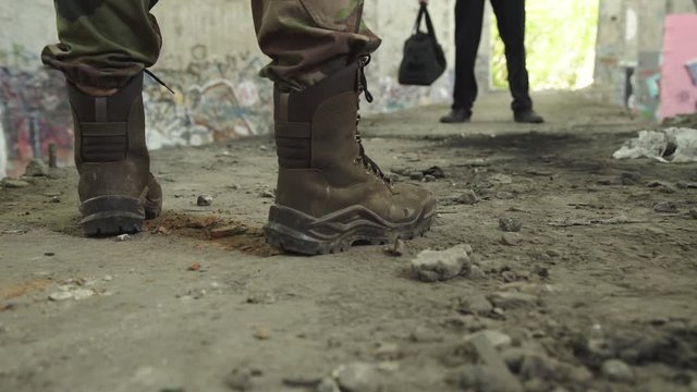 Low view of businessman throws a bag with money to bandits at abandoned building