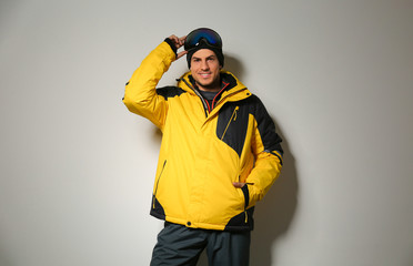 Man wearing stylish winter sport clothes on light grey background