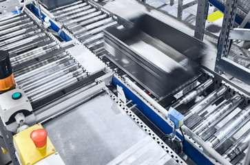 Modern conveyor system with box in motion, shallow depth of field.
