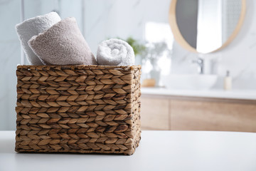 Fototapeta premium Wicker basket with clean soft towels in bathroom. Space for text
